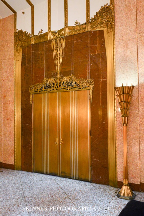 Brass and copper doors with marble surround
